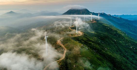 Wind farm on a green hill shrouded in mist - How green bonds can bolster the transition towards a more sustainable future